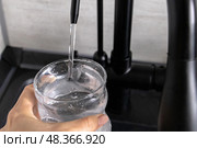Clean filtered water from flow-through three-stage purifying water filtration system. Стоковое фото, фотограф Наталья Симакова / Фотобанк Лори