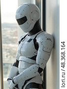 The humanoid robot stands motionless by a window, reflecting sunlight while looking out over a sprawling urban landscape in the background. Стоковое AI-изображение, AI-художник Данила Большаков / Фотобанк Лори