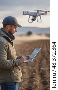 Farmer using laptop controlling drone over field. Стоковое AI-видео, аниматор Юрий Поздников / Фотобанк Лори