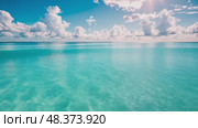 Turquoise waters reflect sunlight amidst a backdrop of fluffy clouds, creating a tranquil atmosphere perfect for relaxation and nature appreciation. Стоковое AI-видео, аниматор Данила Большаков / Фотобанк Лори