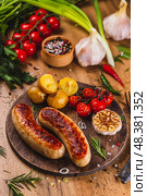 Колбаски пожаренные на гриле с чесноком и картошкой. Стоковое фото, фотограф Светлана Денисова / Фотобанк Лори