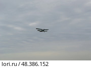 Полёт лёгкого пассажирского самолёта АН-2 под облачным небом. Волгоградская область, Средняя Ахтуба, Россия. (2022 год). Редакционное фото, фотограф Андрей Цыганков / Фотобанк Лори
