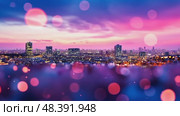 Colorful lights illuminate the city skyline at night, showcasing tall buildings and a captivating sunset backdrop. The vibrant hues create a stunning visual experience from a high vantage point. Стоковое AI-видео, аниматор Данила Большаков / Фотобанк Лори