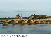 View of the embankment with ancient houses and the Jacques Gabriel Bridge over the Loire River on a sunny summer day, Blois, Loire and Cher, France. Стоковое фото, фотограф Ula Ulachka / Фотобанк Лори
