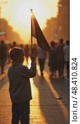 A child holding a small black flag, standing in a crowded street at sunset, the golden light casting long shadows as people march. Стоковое AI-видео, аниматор Sergey Grishin / Фотобанк Лори