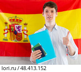 Young guy posing with documents on background of flag of Spain. Стоковое фото, фотограф Татьяна Яцевич / Фотобанк Лори