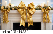 mantel gold christmas bow ai generated. Стоковое AI-изображение, AI-художник Vectorwin / Фотобанк Лори