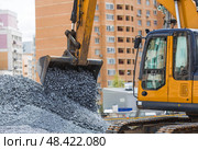 Heavy machinery for construction and landscaping. An excavator on a construction site in close-up. An excavator loads crushed stone into a bucket for construction. Стоковое фото, фотограф Photojuli / Фотобанк Лори