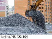 Heavy machinery for construction and landscaping. An excavator on a construction site in close-up. An excavator loads crushed stone into a bucket for construction. Стоковое фото, фотограф Photojuli / Фотобанк Лори