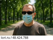 Мужчина в маске. Человек в маске на улице в период цветения, защищаясь от пыльцы и аллергенов. Стоковое AI-изображение, AI-художник Башкирова Анна / Фотобанк Лори
