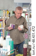 European chooses with interest scented candles made of paraffin and soy wax in the household section of a supermarket. Стоковое видео, видеограф Яков Филимонов / Фотобанк Лори