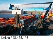 Портовый кран перегружатель / манипулятор в морском порту в в трюмы балкера загружает минеральные удобрения (2014 год). Стоковое фото, фотограф Павел Просянов / Фотобанк Лори
