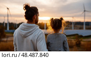 Father and daughter looking at solar panels. Solar farm and sunlight at sunset. Solar energy for green energy. Sustainable renewable energy. Photovoltaic power plant or solar park. Energy sustainability. Стоковое AI-изображение, AI-художник ALLA YURTAYEVA / Фотобанк Лори