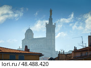 Basilique Notre-Dame de la Garde in the foggy background with red tiled roof Marseille houses (2018 год). Стоковое фото, фотограф Сергей Богомяко / Фотобанк Лори