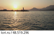 Experience the tranquil beauty of the Adriatic Sea as ships glide through shimmering waters. Witness the sun setting behind majestic mountain scenery, capturing a magical moment in time. Стоковое видео, видеограф Юлия Петровская / Фотобанк Лори