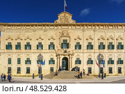 VALLETTA, MALTA - NOVEMBER 12, 2018 - Exterior view of the Auberge de Castille in Castille Square with people walking by. Редакционное фото, фотограф Сергей Богомяко / Фотобанк Лори