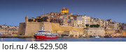 VALLETTA, MALTA - NOVEMBER 12, 2018 - Panoramic view of the Grand Harbor Tricity bay, Birgu and Senglea islands with ships and boats in the port. Редакционное фото, фотограф Сергей Богомяко / Фотобанк Лори