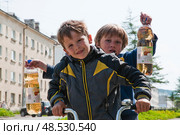 Довольные мальчишки с двумя бутылками газированной воды на улице Магадана (2012 год). Редакционное фото, фотограф Павел Просянов / Фотобанк Лори