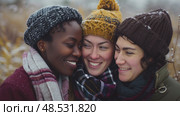 Three women huddle closely, smiling and enjoying each others company against a backdrop of faintly visible trees shedding their leaves. Стоковое AI-изображение, AI-художник Данила Большаков / Фотобанк Лори