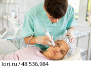 Young male cosmetologist doing microcurrent procedure to young woman. Стоковое фото, фотограф Яков Филимонов / Фотобанк Лори