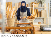 Portrait of female salesperson in a niqab at the cash register of private bakery. Стоковое фото, фотограф Яков Филимонов / Фотобанк Лори