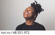 African American woman wearing a black shirt is seen laughing joyfully, her mouth wide open and eyes crinkled with mirth. Стоковое AI-изображение, AI-художник Данила Большаков / Фотобанк Лори
