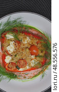 Vegetarian gourmet bell pepper filled with couscous, feta, zucchini, tomatoes, spinning slowly on white ceramic plate, dark backdrop. Стоковое видео, видеограф Данил Руденко / Фотобанк Лори