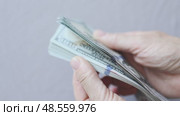 shuffling stack pack of hundred 100 dollar bills on light grey background. Стоковое видео, видеограф Olesia Kondrateva / Фотобанк Лори