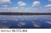 Clouds are reflected in smooth water of lake - timelapse, 4k. Стоковое видео, видеограф Михаил Коханчиков / Фотобанк Лори