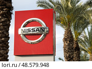 Rishon Lezion, Israel - May 15,2025. Nissan dealership sign with palm trees. Редакционное фото, фотограф Георгий Дзюра / Фотобанк Лори
