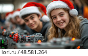 Students in Santa hats participate in a hands-on robotics workshop, collaborating on projects and demonstrating their skills in a festive setting. Стоковое AI-изображение, AI-художник Данила Большаков / Фотобанк Лори