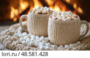 Two knitted mugs filled with hot chocolate, adorned with fluffy marshmallows, rest beside a crackling fireplace in a warm winter atmosphere. Стоковое AI-изображение, AI-художник Данила Большаков / Фотобанк Лори