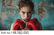Close-up portrait of a young girl with boxing gloves, showing a serious expression. Стоковое AI-изображение, AI-художник Катерина Бондарец / Фотобанк Лори