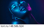 Portrait in Neon: Serene Close-up of a Woman Bathed in Futuristic Blue and Purple Light. Стоковое AI-изображение, AI-художник Данила Большаков / Фотобанк Лори