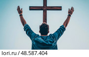 Faith and Freedom: Man Reaching for Hope Under the Cross. Стоковое AI-изображение, AI-художник Данила Большаков / Фотобанк Лори