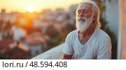A serene elderly man sits quietly on a balcony, meditating as the sun sets over the city rooftops, reflecting peaceful energy on his face. Стоковое AI-изображение, AI-художник Данила Большаков / Фотобанк Лори