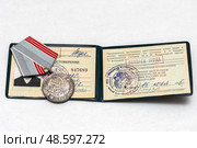 Медаль "Ветеран труда" лежит на удостоверение. Редакционное фото, фотограф Игорь Низов / Фотобанк Лори