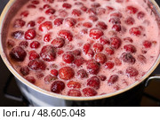 Bubbling red strawberry berries create a vibrant mixture as they simmer in a pot. Стоковое фото, фотограф Виктория Тельминова / Фотобанк Лори