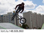 Belarus, Gomel, June 24, 2018. Central park. Extreme cycling.A dangerous trick on a bicycle against the backdrop of the city. Редакционное фото, фотограф Лазаренко Светлана / Фотобанк Лори