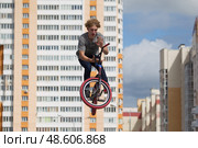 Belarus, Gomel, June 24, 2018. Central park. Extreme cycling.A dangerous trick on a bicycle against the backdrop of the city.Professional cyclist jumped high. Редакционное фото, фотограф Лазаренко Светлана / Фотобанк Лори