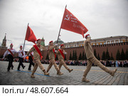 Знаменосец с красным знаменем Пионерской организации и копией Знамени Победы на торжественной линейке, посвященной приему в пионеры на Красной площади города Москвы, Россия. Редакционное фото, фотограф Николай Винокуров / Фотобанк Лори