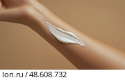 Moisturizing cream applied on a hand for skincare routine. Увлажняющий крем, нанесенный на руку для ухода за кожей. Стоковое AI-изображение, AI-художник Katsiaryna Repich / Фотобанк Лори