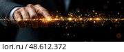 A hand reaches out to touch a shimmering line of golden particles against a dark background, evoking themes of invention and inspiration. Стоковое AI-изображение, AI-художник Данила Большаков / Фотобанк Лори