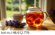 An elegant glass teapot filled with vibrant herbal tea sits next to a white cup and fresh lavender flowers in bright afternoon sunlight. Стоковое AI-изображение, AI-художник Данила Большаков / Фотобанк Лори