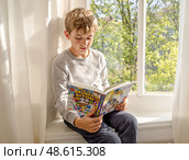 Спокойный мальчик сидит у школьного окна и читает книгу, его задумчивый взгляд устремлен на текст. Солнечный день дарит ощущение безмятежности и счастья. Стоковое AI-изображение, AI-художник Сергей Никифоров-Гордеев / Фотобанк Лори