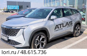 Geely Atlas vehicle next the showroom of official dealer. Chinese automobile manufacturer. Редакционное видео, видеограф FotograFF / Фотобанк Лори