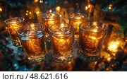 Whiskey glasses filled with amber liquid sit on a bar, illuminated by soft candlelight, creating a warm, inviting atmosphere in a tavern. Стоковое AI-изображение, AI-художник Данила Большаков / Фотобанк Лори