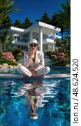 A woman is sitting on a pool deck, drinking a beverage. Стоковое AI-изображение, AI-художник Ярославский Максим / Фотобанк Лори