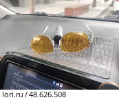 Очки и табличка с номером телефона водителя на торпедо автомобиля. Glasses and a sign with the driver's phone on the car's dashboard. 眼镜和汽车仪表板上带有驾驶员电话的标志。 Стоковое фото, фотограф Денис Баданин / Фотобанк Лори