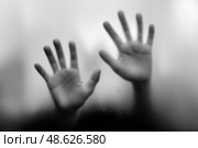 Shadows of desperation against a foggy glass surface in a dimly lit room. Тени отчаяния на фоне туманной стеклянной поверхности в тускло освещенной комнате. Стоковое AI-изображение, AI-художник Katsiaryna Repich / Фотобанк Лори
